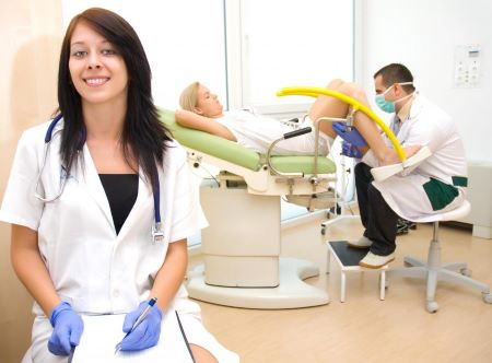 smiling-nurse-near-doctor-and-woman-in-stirrups.jpg