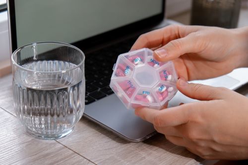 woman-sorting-pills-organizer-weekly-shots-closeup-2023-11-27-05-18-25-utc.jpg