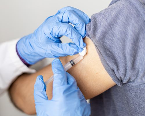 doctor-with-blue-gloves-giving-injections-from-arm-2023-11-27-05-19-51-utc.jpg