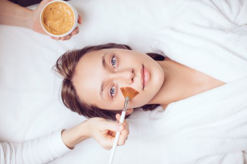 cosmetologist-applying-mask-with-brush-to-awesome-2024-04-22-19-30-18-utc.jpg
